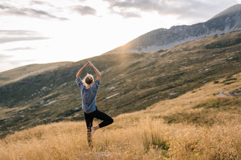 Young Woman Preforms Yoga In Mountains In Morning Light